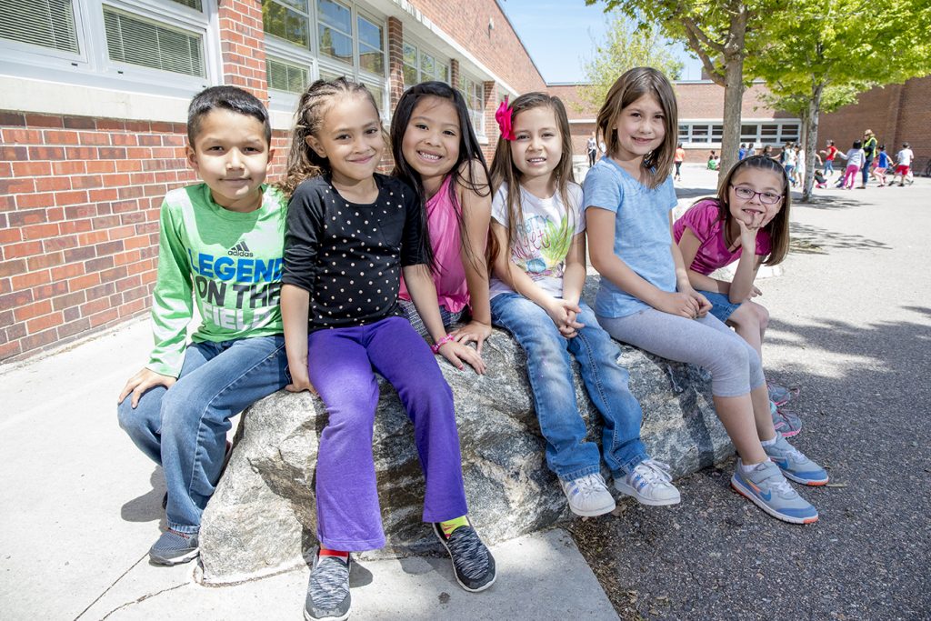 children sitting outside in the sunshine